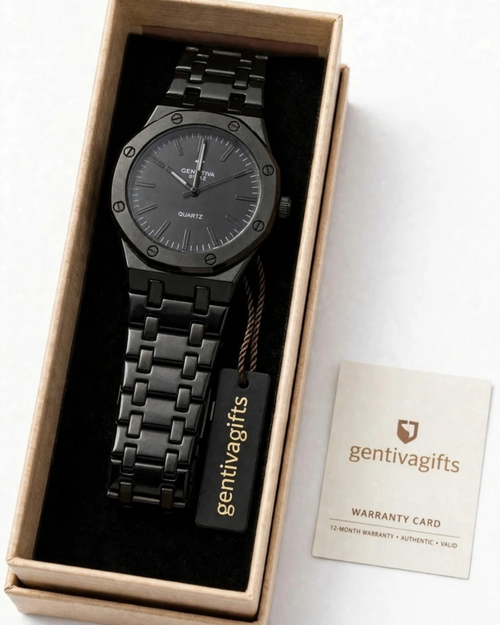 A black metal wristwatch presented in an open kraft gift box with a black interior, alongside a warranty card and branded hangtag. The watch has a dark gray dial and a matching black link bracelet.
